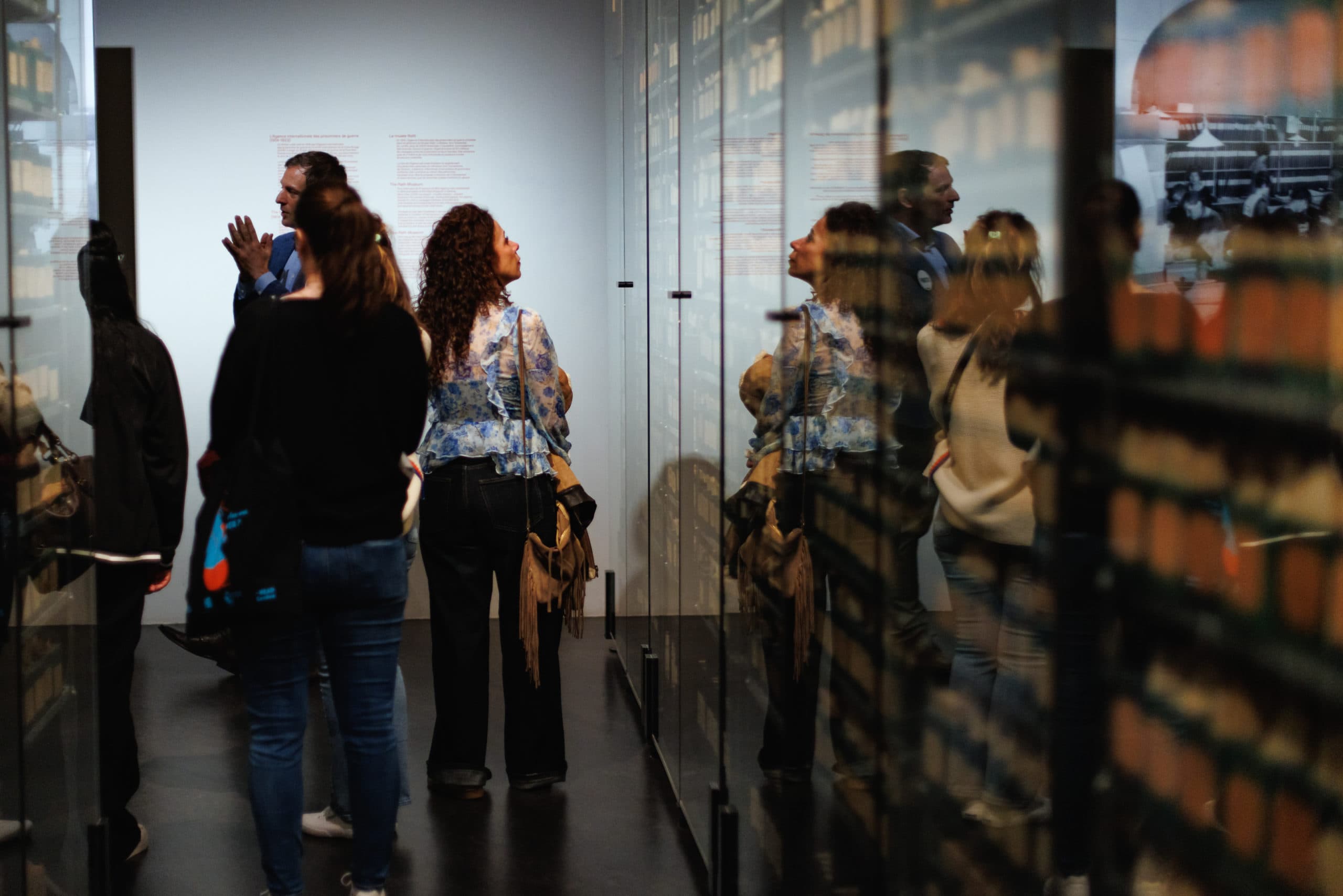 A group of visitors standing in front of display cases, looking at their contents.
