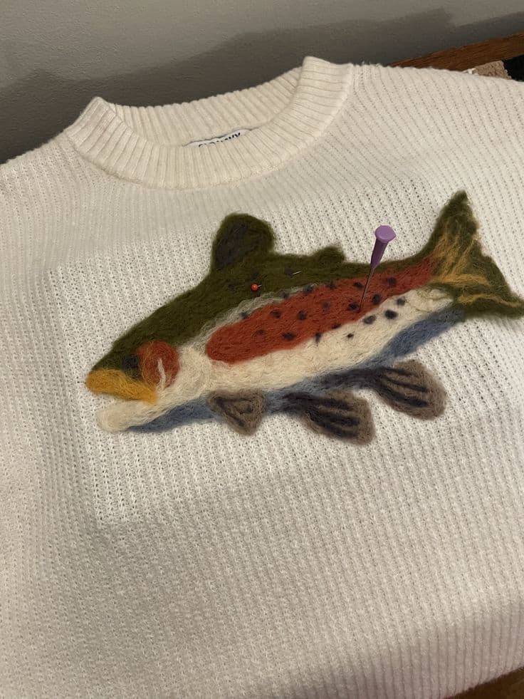 Fisch aus Filz auf einem weißen Wollpullover